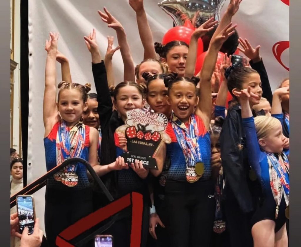 Several Girls on Team on podium celebrating winning