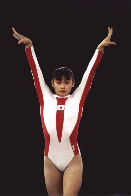 Mari Kosuge former GW noteworthy coach on floor with white red leo